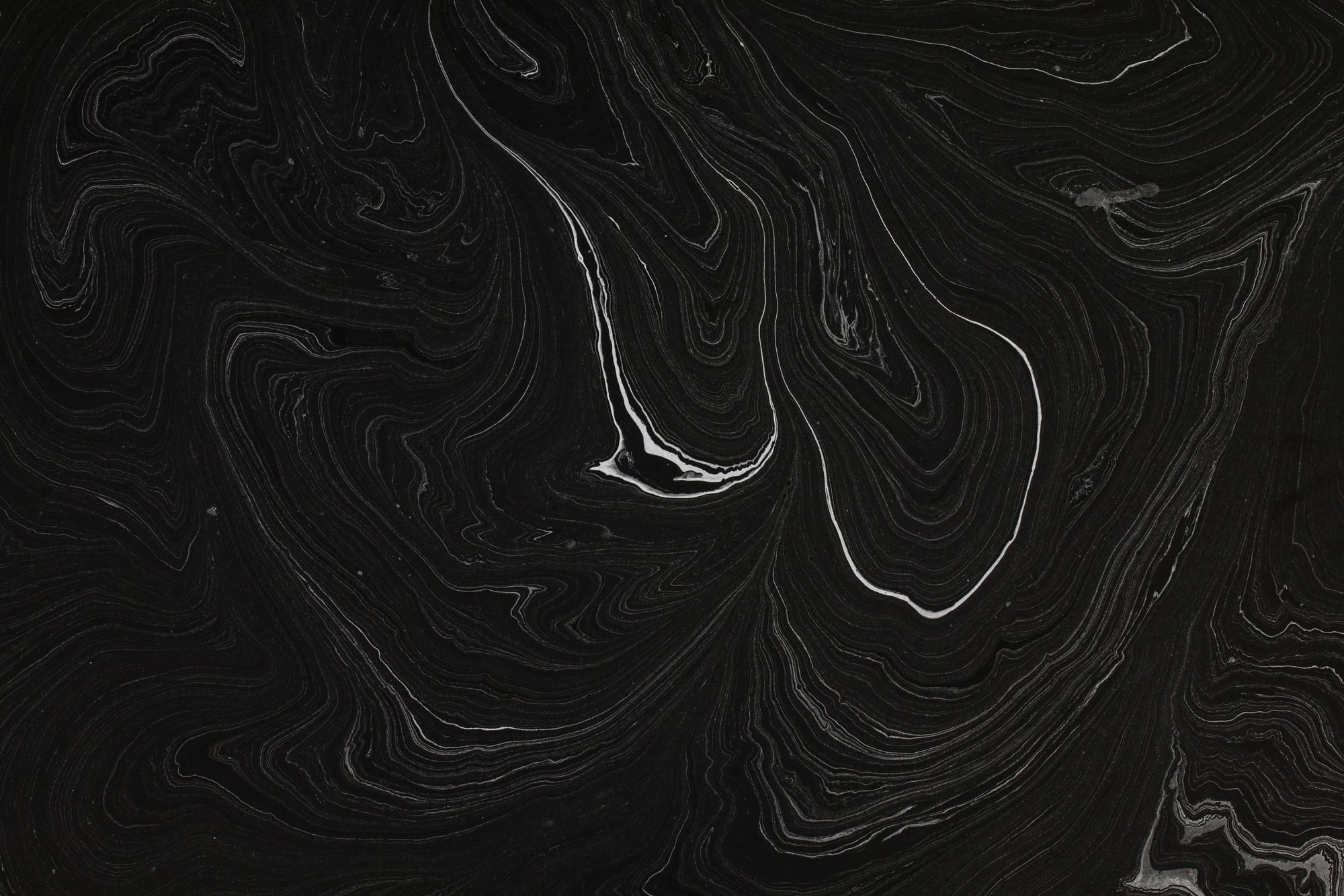 Fine pale striations across a near-black abstract surface